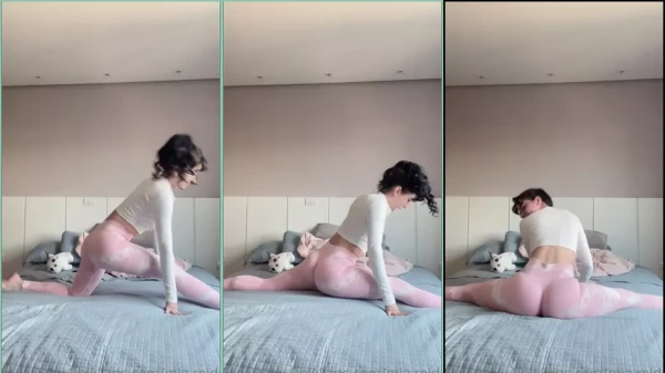 Mia Reid de calça legging rosa dando um rolê na cama em vídeo