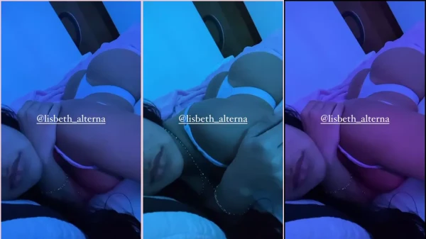 Lisbeth, com seu cabelo volumoso e moreno, está relaxando de calcinha na cama